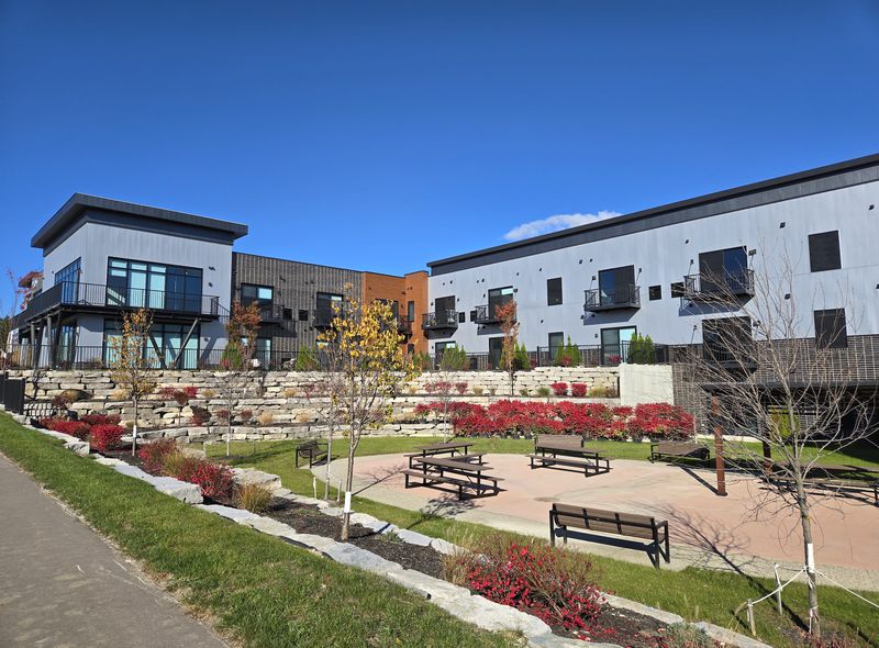 Mixed-use apartment buildings beside a landscaped plaza